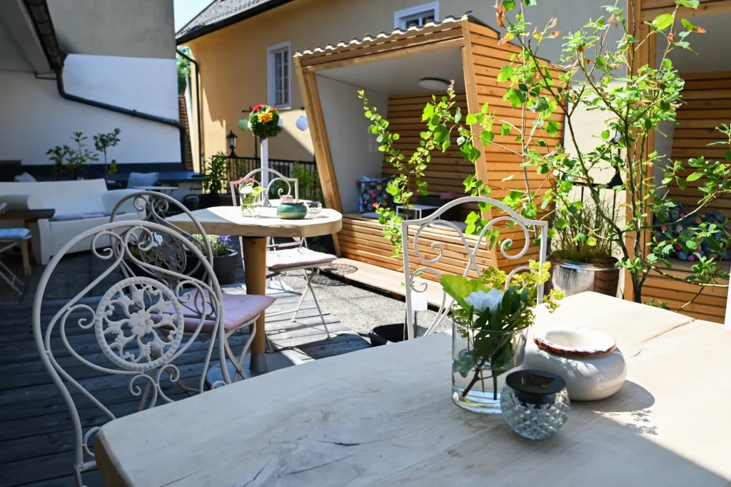 Dekorierte Terrasse mit Tischen, Blumen und Sitzplätzen im Freien