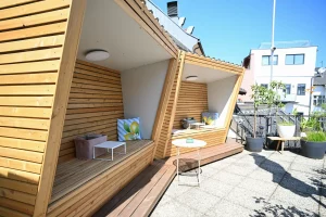 Überdachte Holz-Sitznischen auf moderner Terrasse in Villach mit gemütlichen Sitzplätzen